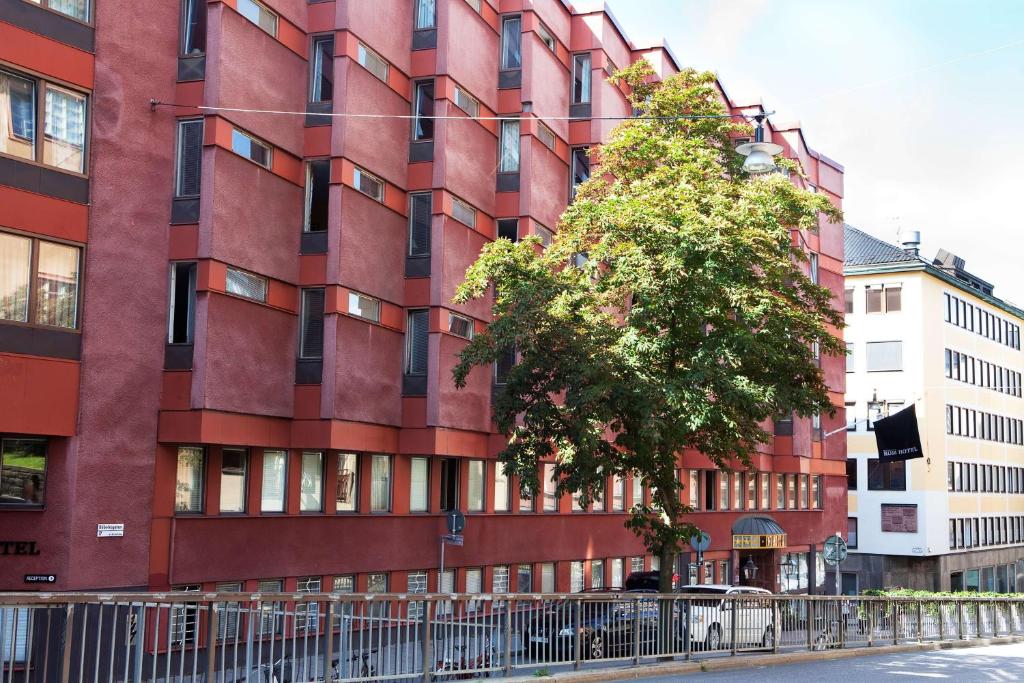 斯德哥尔摩康姆贝斯特韦斯特酒店的前面有棵树的红色建筑