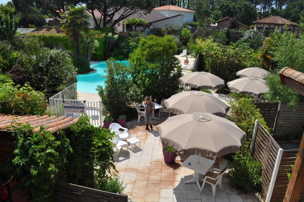 米米藏亚特兰蒂斯酒店的一个带桌子和遮阳伞的庭院和一个游泳池