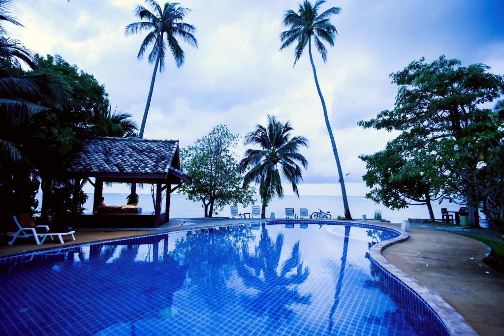 拉迈Grand Manita Beach Resort的一座棕榈树环绕的游泳池