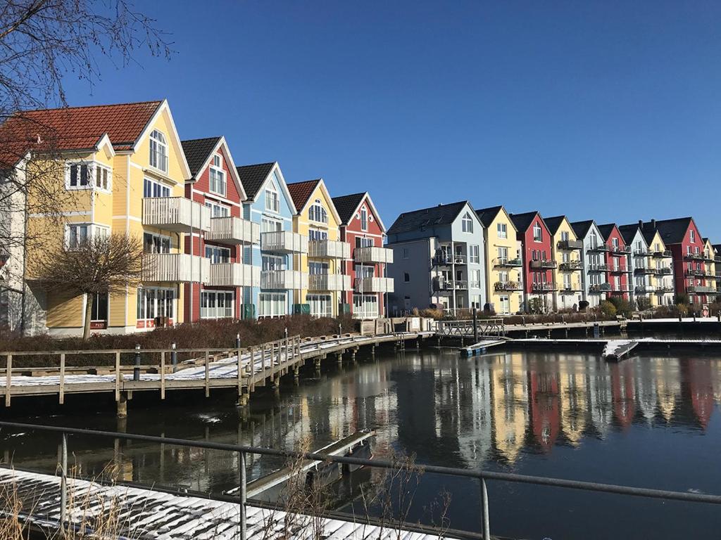 格赖夫斯瓦尔德Am Altstadt - Yachthafen的河边一排色彩缤纷的房屋