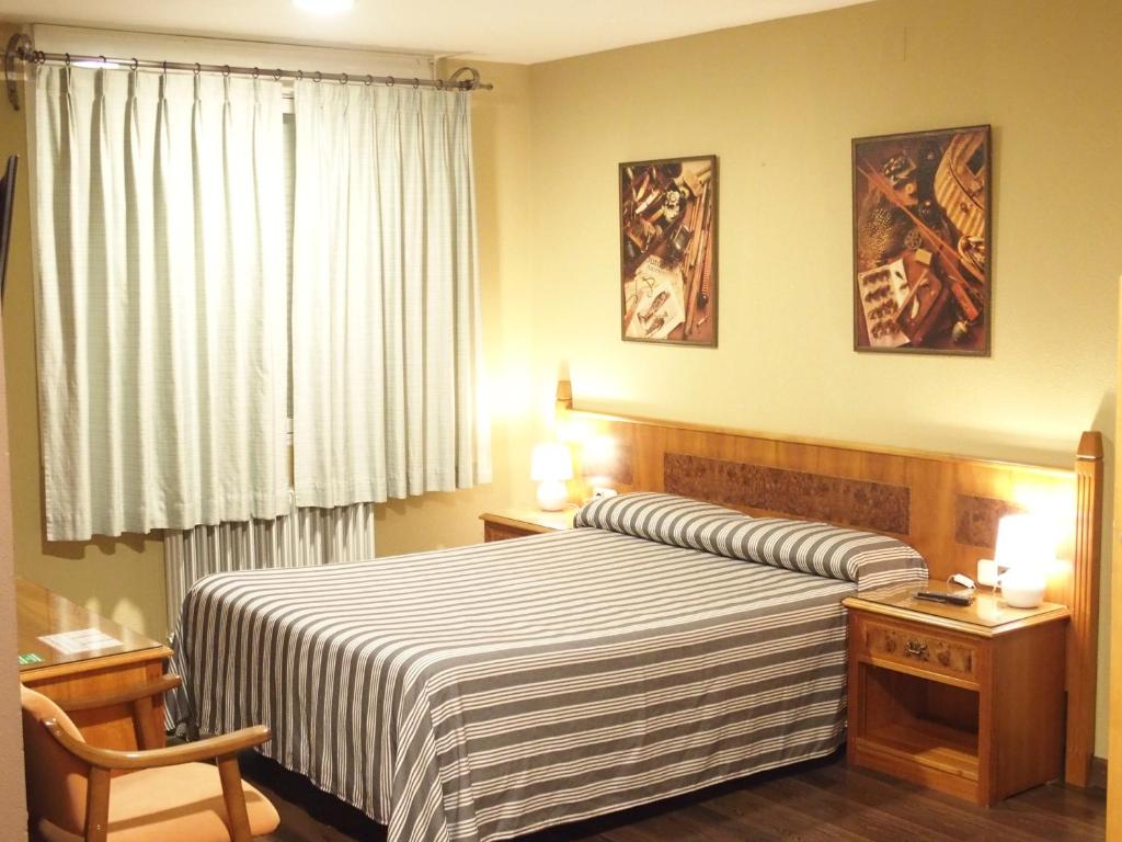 比利亚尔瓦德拉谢拉塔布拉左酒店的一间卧室配有一张带条纹毯子的大床