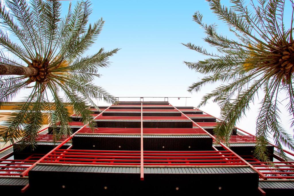 甘迪亚博尔吉亚酒店的一座红色楼梯和两棵棕榈树的建筑