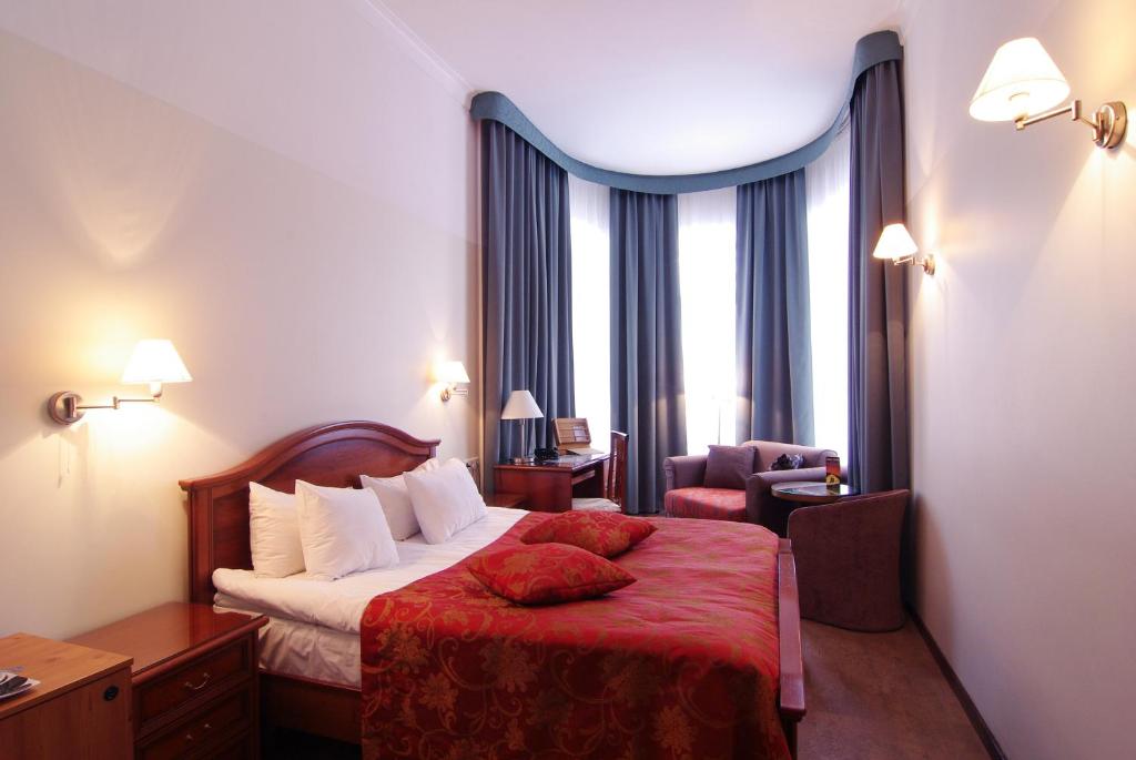 塔林圣芭芭拉酒店的酒店客房,配有一张带红色毯子的床