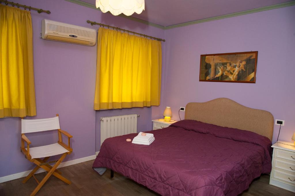 卢卡Residence Tourist的一间卧室配有床、黄色窗帘和椅子