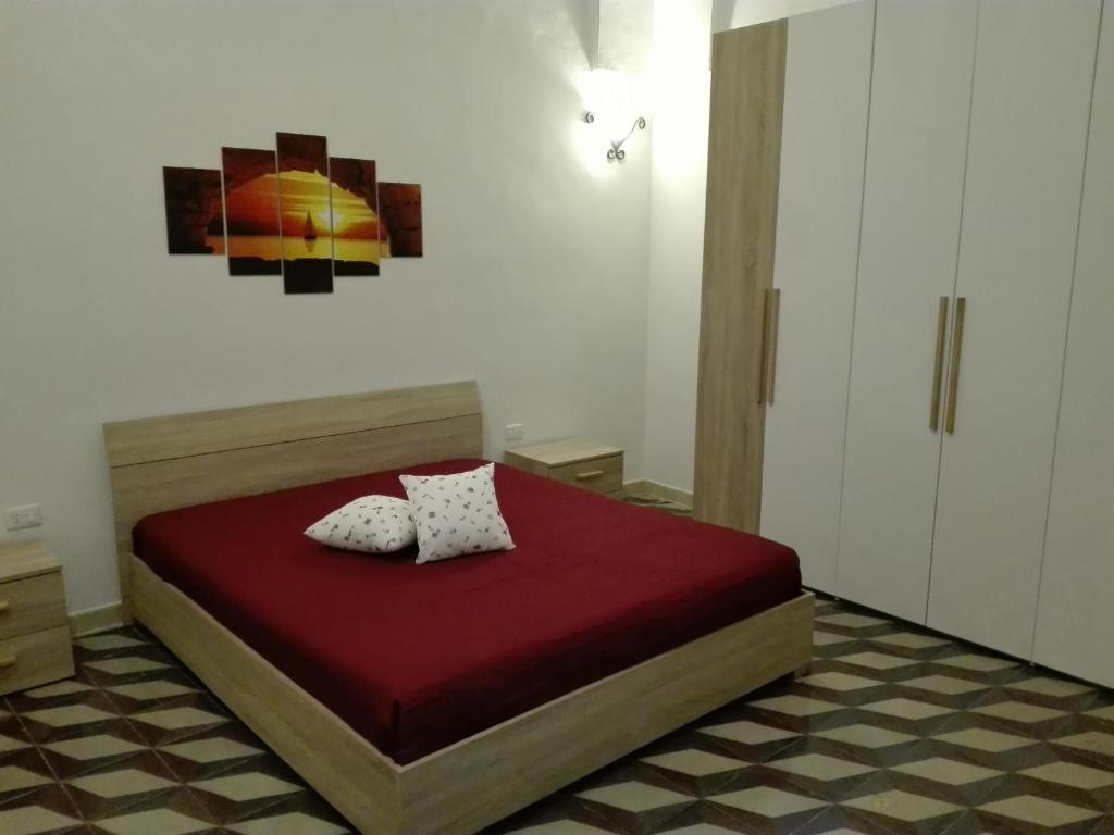 曼杜里亚Casa davide的一间卧室配有红色的床和两个枕头