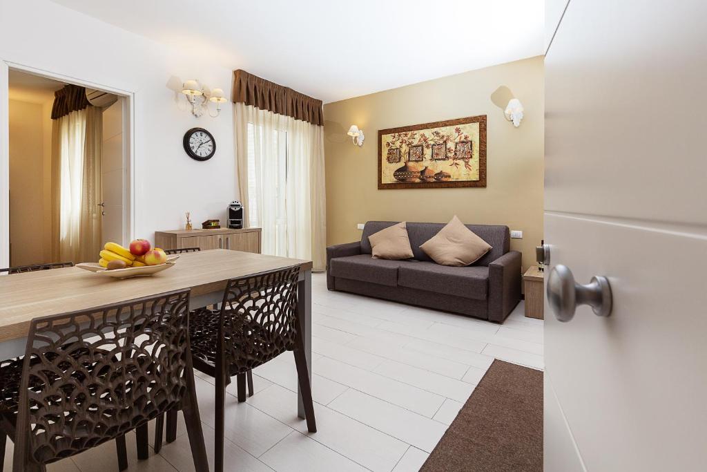 奥尔比亚中心公寓式酒店的厨房以及带桌子和沙发的客厅。
