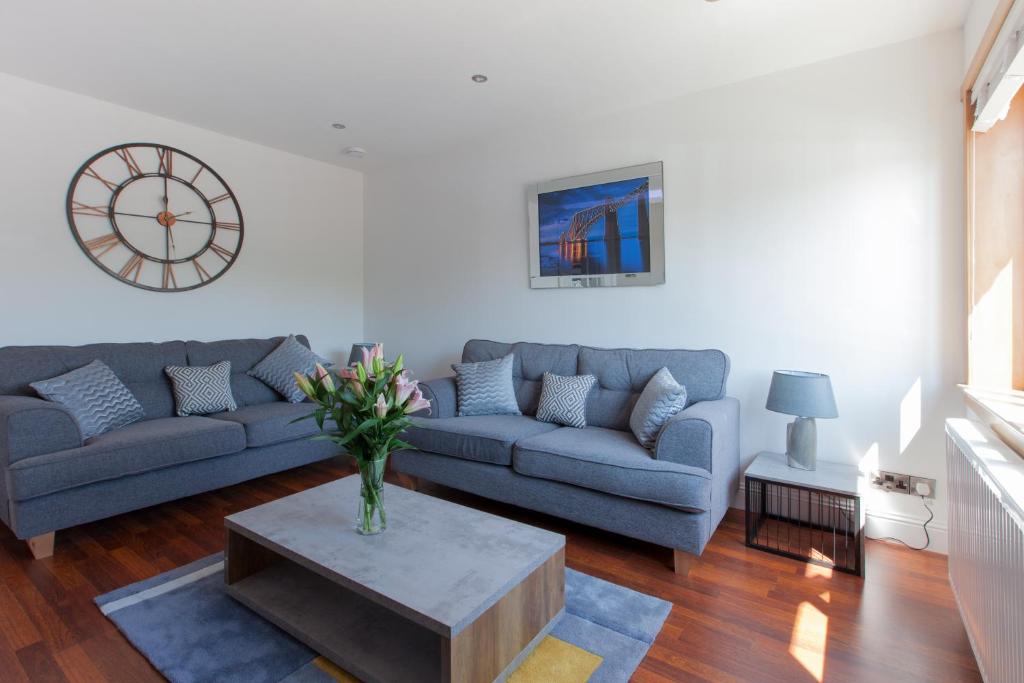 邓弗姆林Leys Park Executive Apartments的客厅配有沙发和桌子