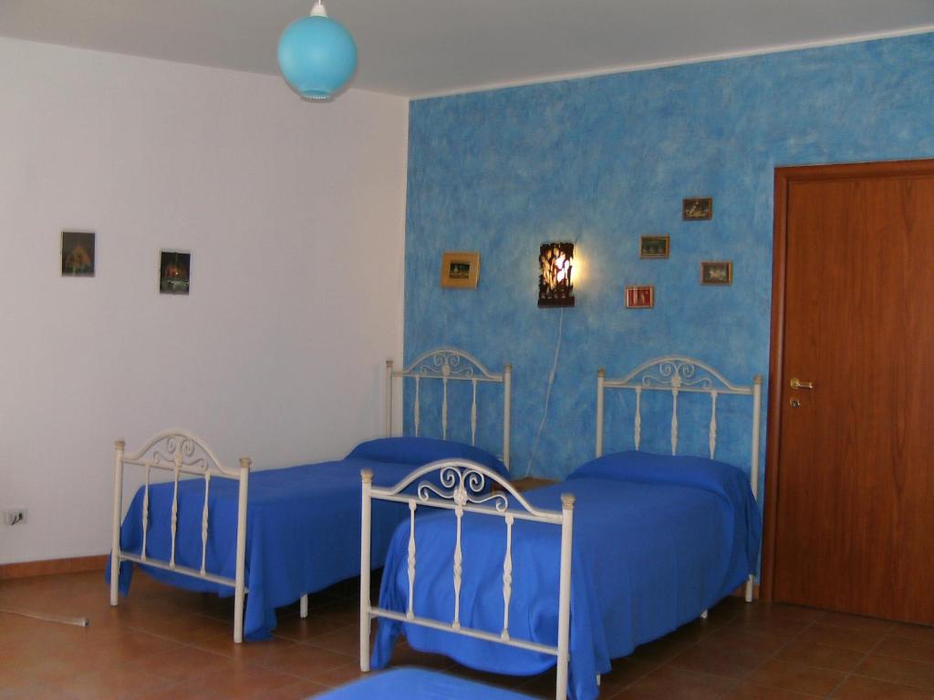 圣卡塔尔多文托戴尔斯特住宿加早餐旅馆的卧室设有两张床铺和蓝色的墙壁