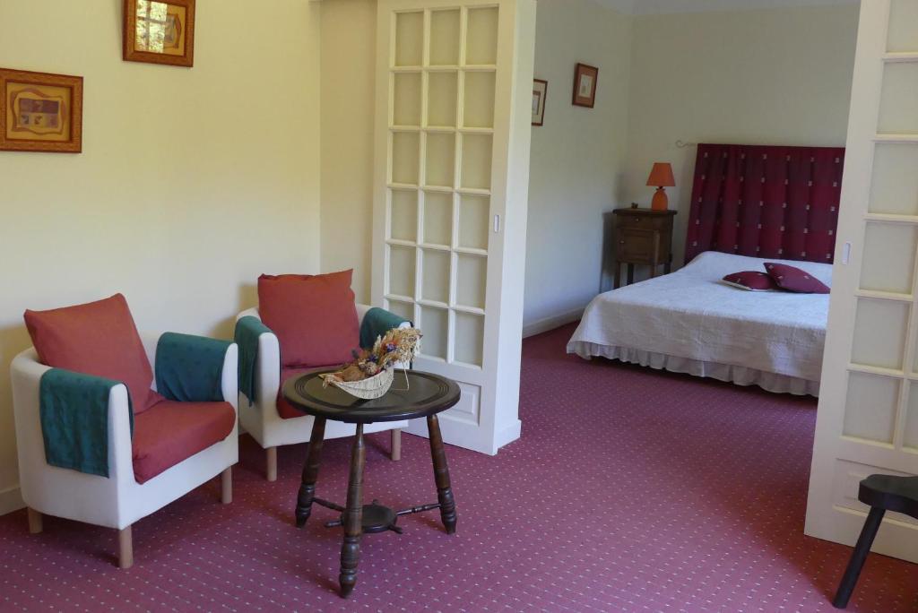 阿斯帕朗尚布里海兹翁多酒店的一间设有两把椅子、一张桌子和一张床的房间