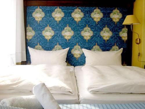 奥斯纳布吕克诺伊施塔特酒店的卧室配有两张带白色枕头的床和蓝色墙壁