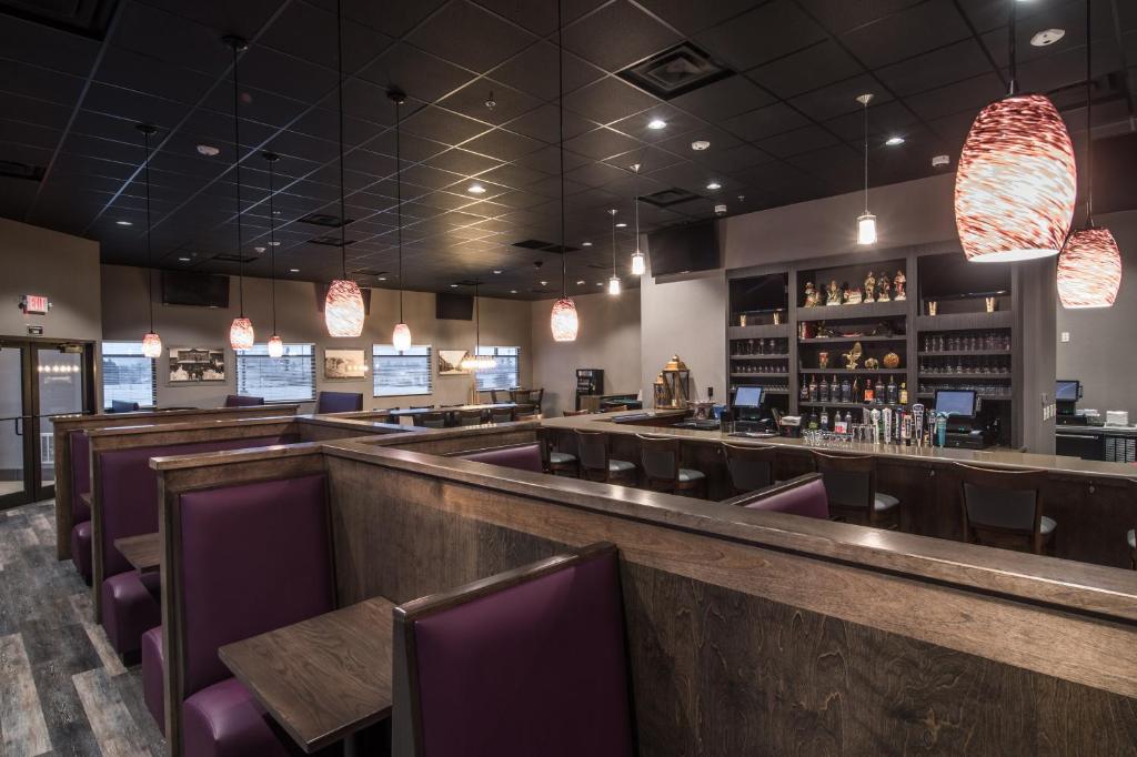 迪金森Astoria Extended Stay & Event Center的餐厅设有1间带紫色椅子的酒吧