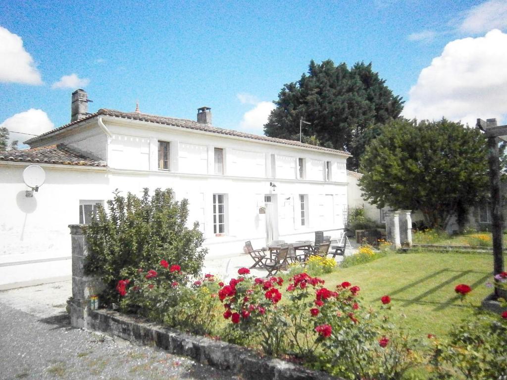 Saint-Fort-sur-GirondeLe Charhido的前面有鲜花的白色房子