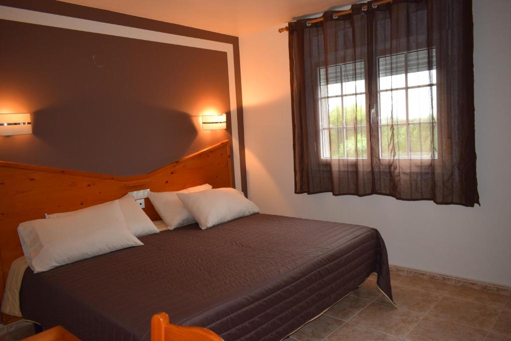 JarrioHotel Restaurante Las Camelias的一间卧室设有一张床和一个窗口