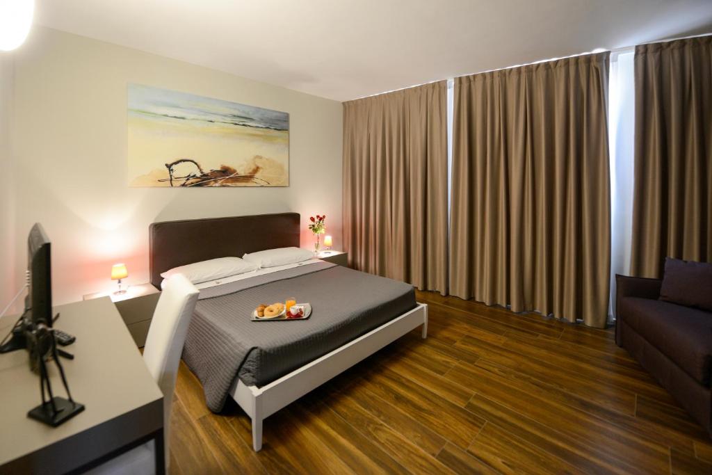 马泰拉马泰拉国立公寓式酒店的一间卧室配有一张床和一张沙发