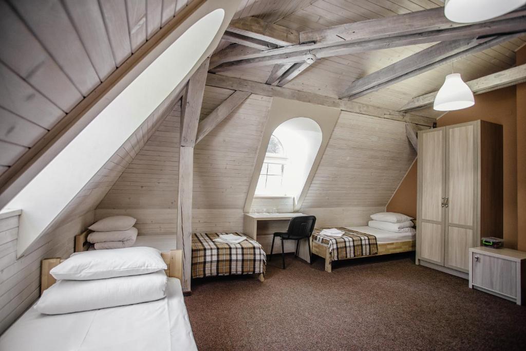 利沃夫Guest House "Arkhistratyg"的阁楼间设有两张床和楼梯。