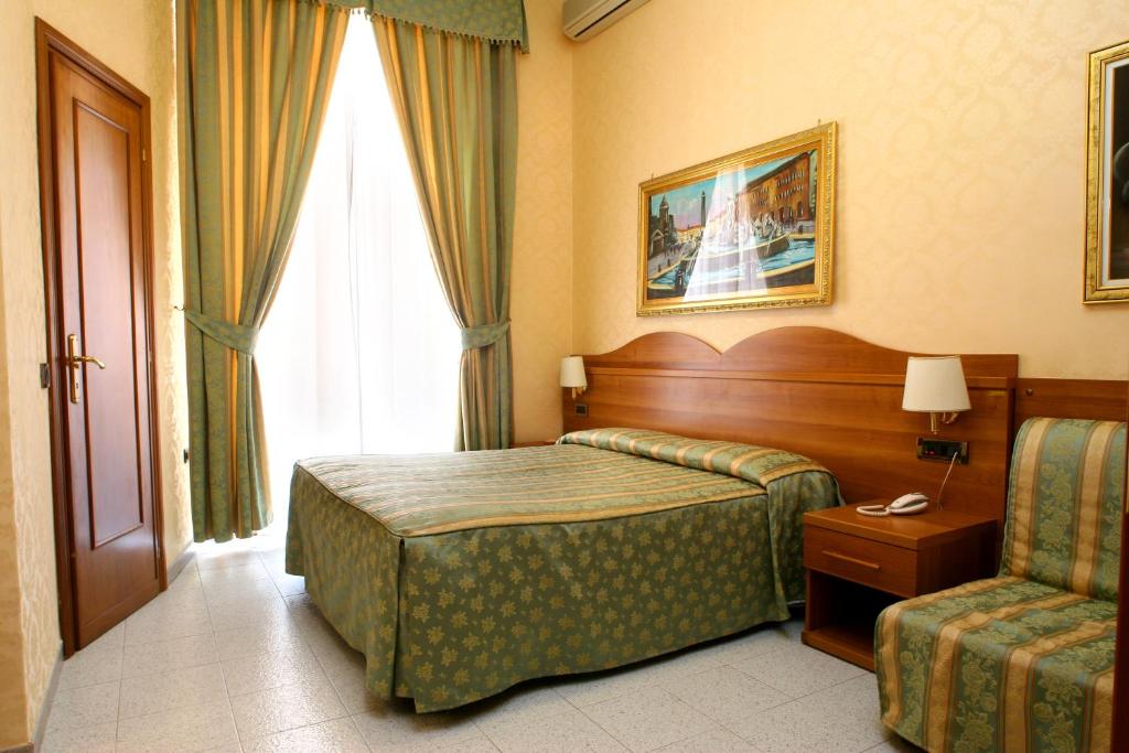 罗马特缇酒店的配有一张床和一把椅子的酒店客房