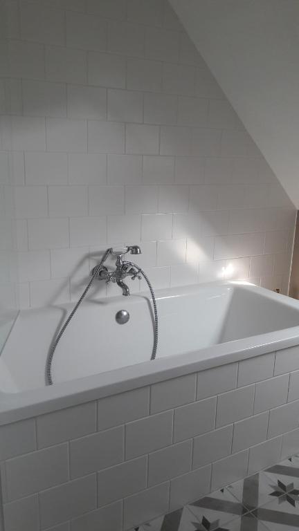 巴特格伦德Villa Pusteblume的浴室设有浴缸和水龙头