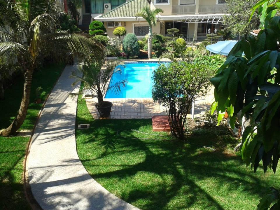 恩卡纳西翁亚瑟香巴拉酒店的一座拥有草地和树木的庭院内的游泳池