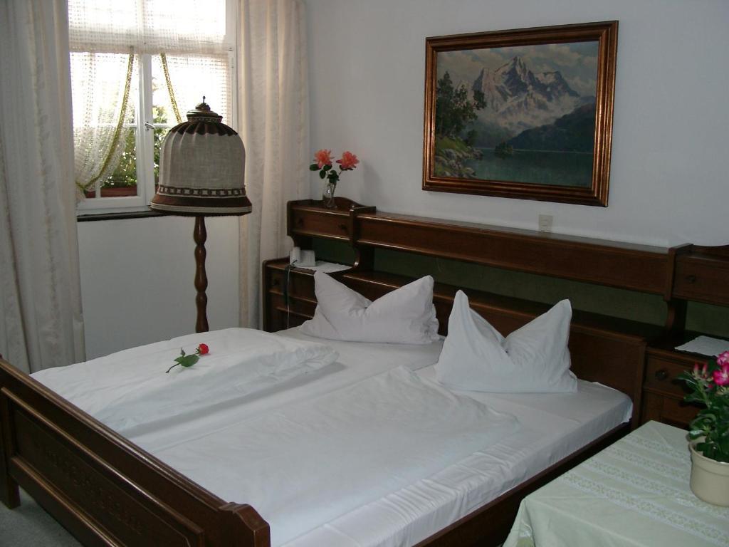 弗莱堡Gasthaus Löwen的一张铺有白色床单的床,上面有花