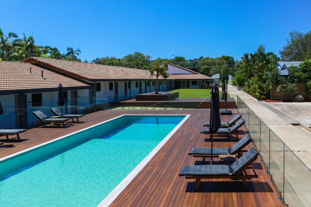 道格拉斯港Birch Resort Port Douglas的一座房子旁带躺椅的游泳池