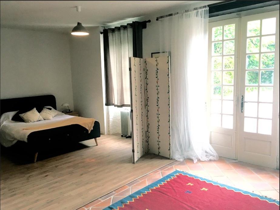 阿尔纳克－蓬帕杜尔Maison Lyre, Pompadour的一间卧室设有一张床和一个大窗户