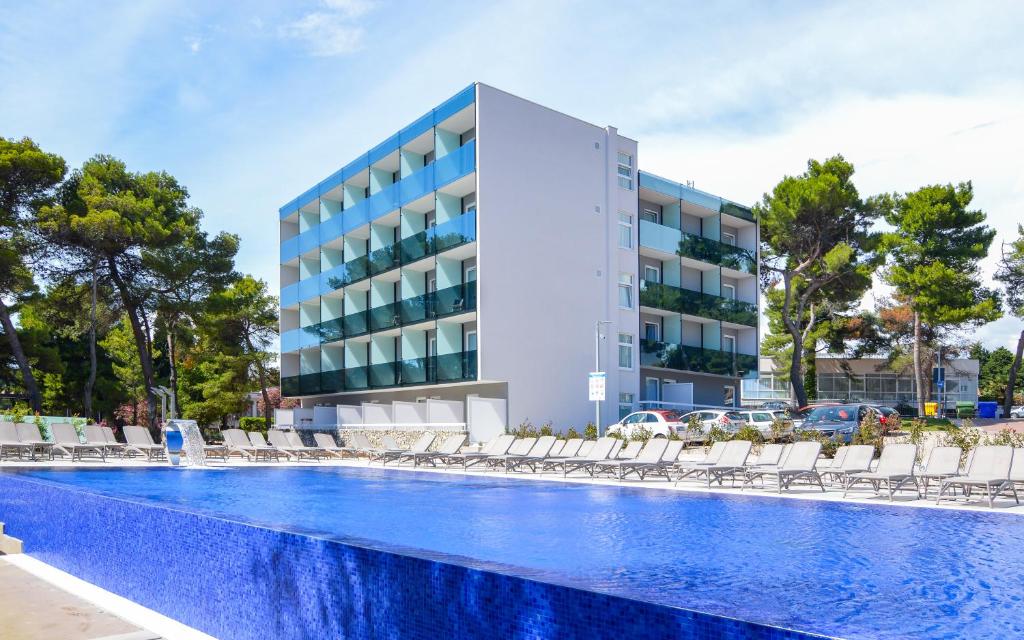 沃迪切Villas Arausana & Antonina的大楼前设有游泳池的酒店