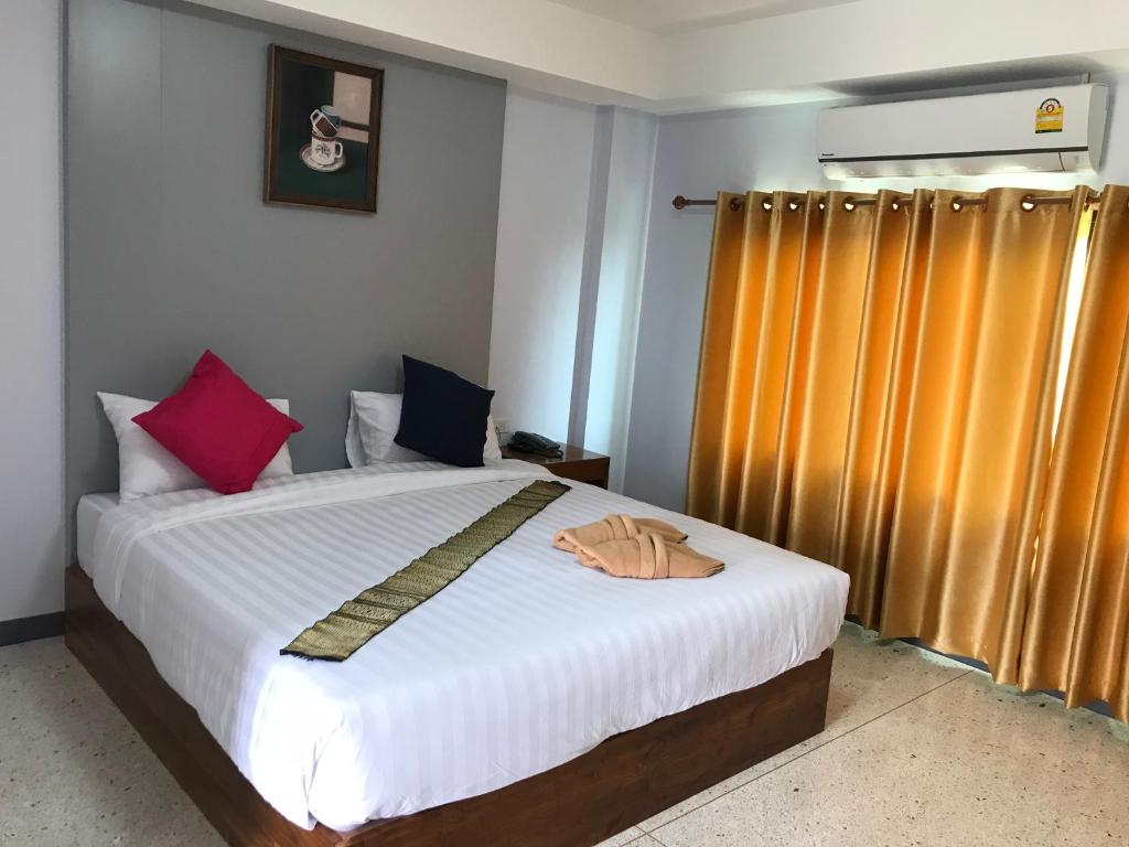 程逸府@ RocKo Hotel的一间卧室配有带白色床单和色彩缤纷的枕头的床。