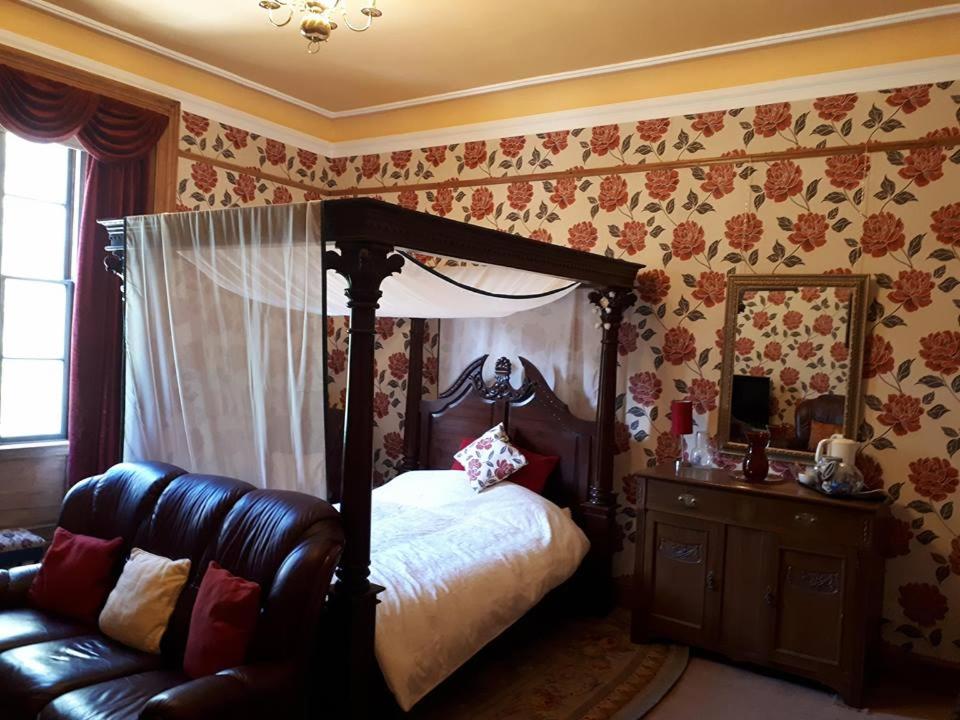 InverbervieHallgreen castle的一间卧室配有天蓬床和沙发