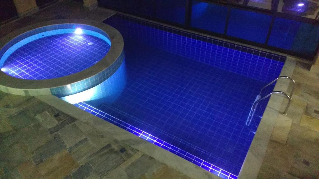 乌巴图巴Pousada Ubuntu的地板上设有蓝色灯光的游泳池