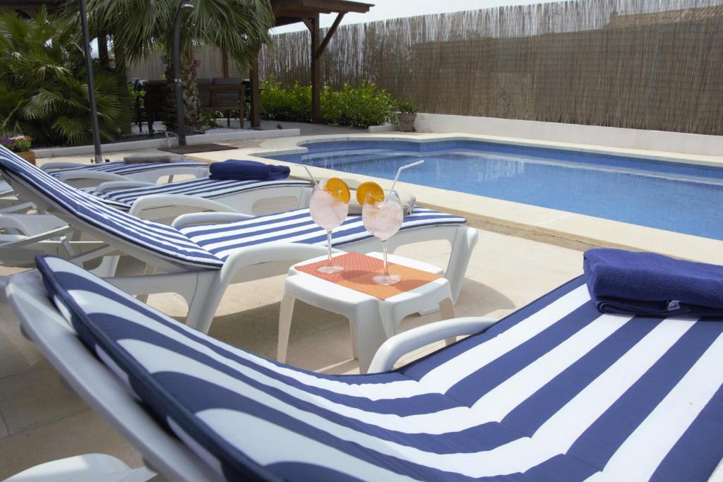 帕特纳Hotel Vista al Sol的一组蓝白色椅子和一个游泳池