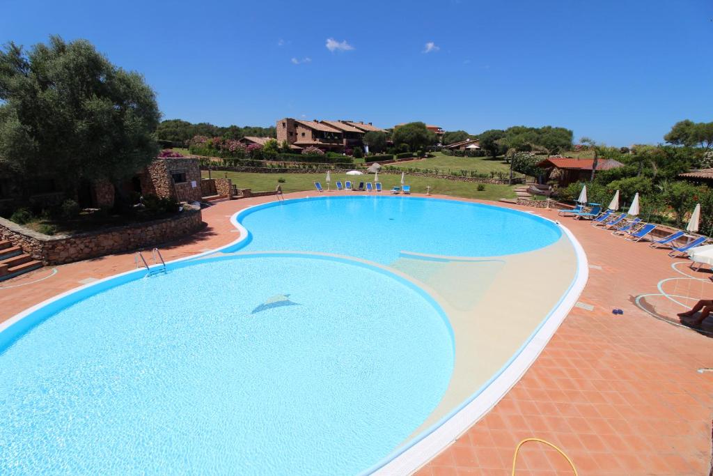 马里内拉Appartamenti residence Vela Blu Golfo Aranci的中央设有海豚的大型游泳池