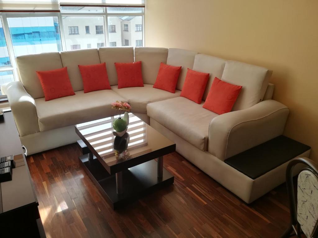 拉巴斯Meraki的客厅配有带红色枕头的白色沙发