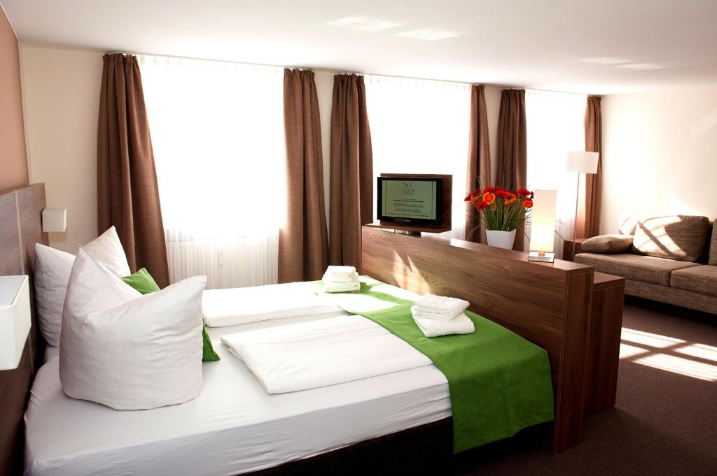 埃赫施塔特Hotel Adler的酒店客房配有一张带绿毯的大床