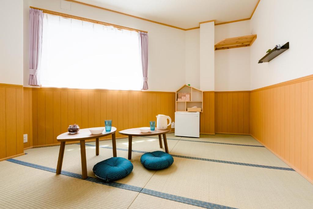 泉佐野ABC民宿的带2张桌子的房间和厨房