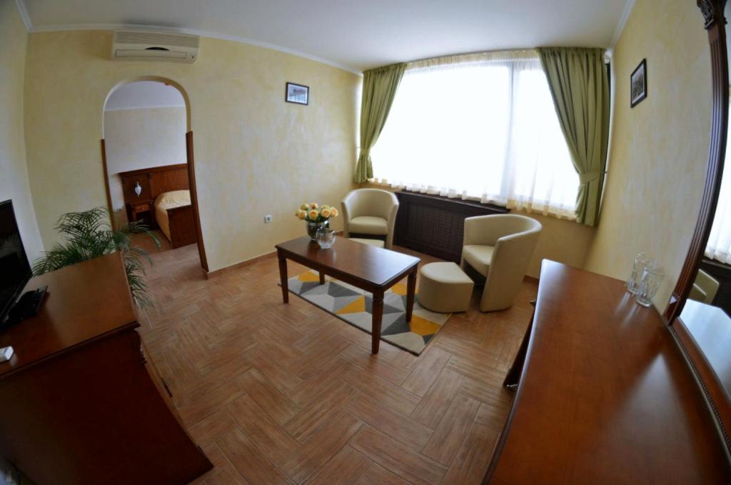 索非亚Central West Hotel的一间客厅,客厅内配有桌椅