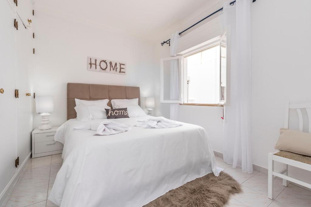 阿尔布费拉Fisherman's Beach Home 2BR 2BA AC Wi-Fi的白色的卧室设有白色的床和窗户。