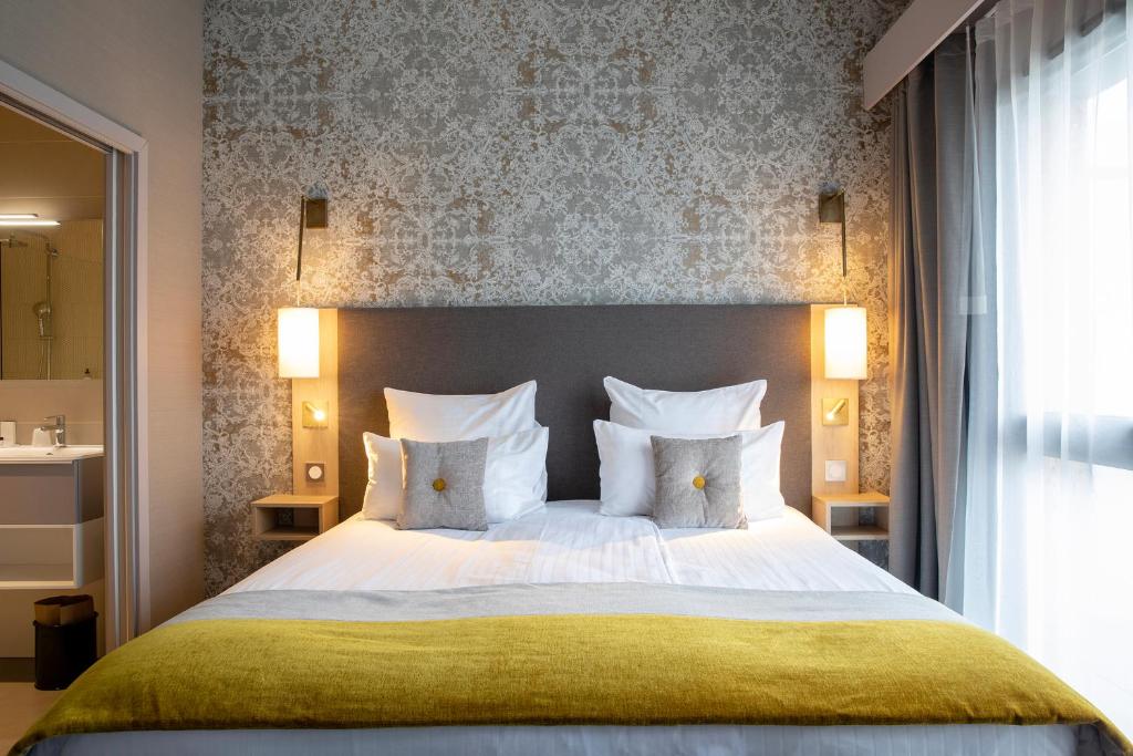 科尔马James Boutique Hôtel Colmar centre的卧室配有一张带白色床单和枕头的大床。
