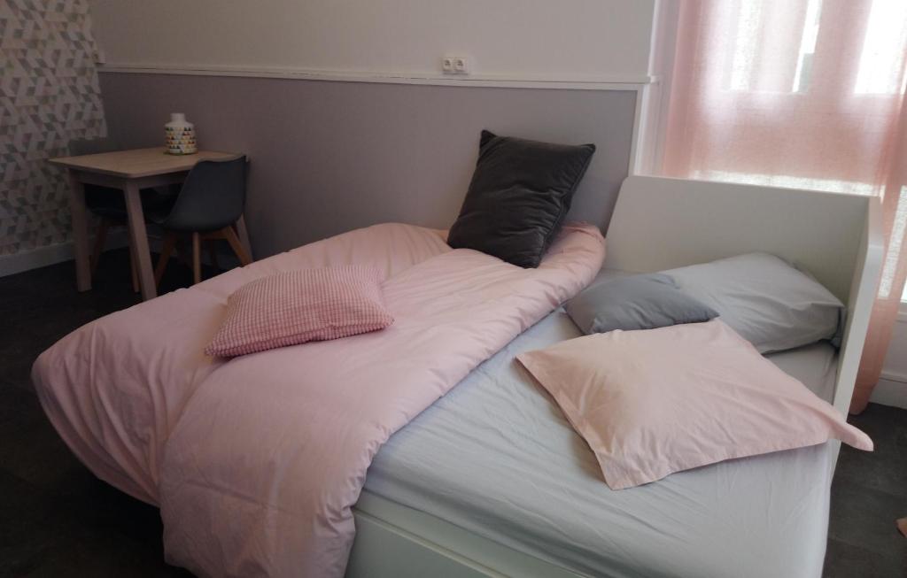 利布尔讷Studio cosy proche Gare的床上有2个枕头