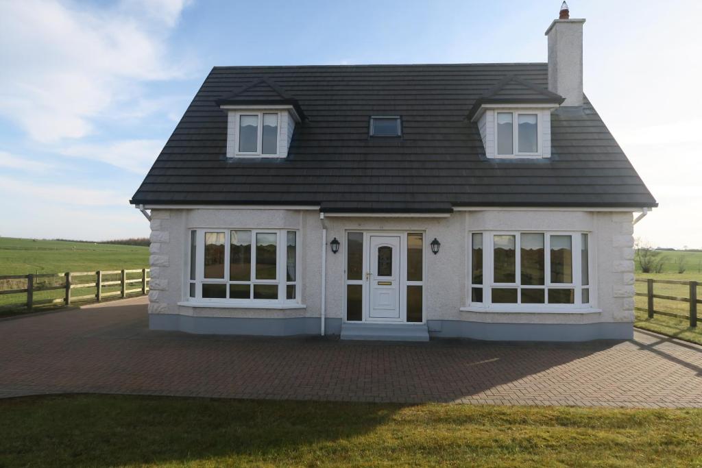 巴利纳THISTLEDOWN - Ballina - Crossmolina - County Mayo - Sleeps 8 - Sister property to Inglewood的黑色屋顶的白色房子