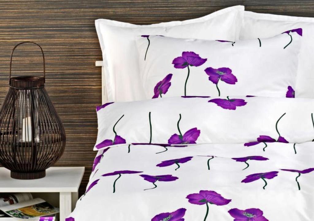 什切青赛特乌公寓酒店的一张布满紫色花的床上