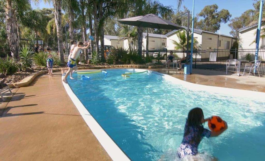 莫阿马墨累河假日公园酒店的一群儿童在游泳池玩球