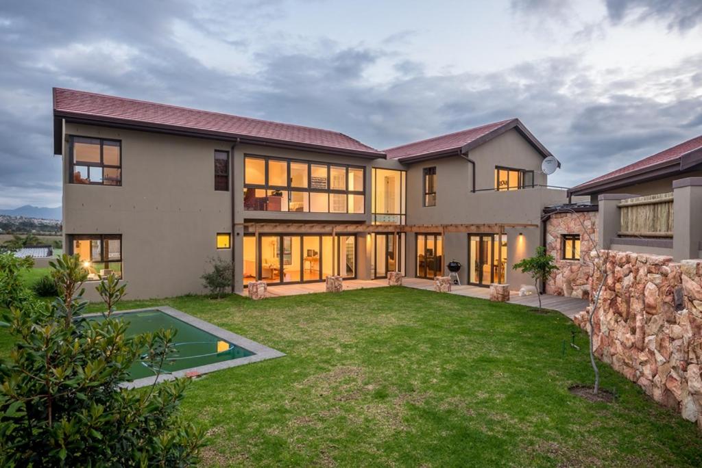 西萨默塞特Modern spacious home in heart of Cape Winelands的大房子,设有大院子和石墙