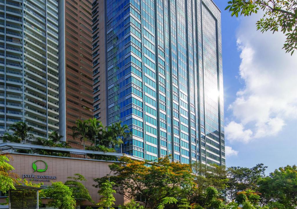新加坡Park Avenue Rochester的一座高大的玻璃建筑,前面有树木