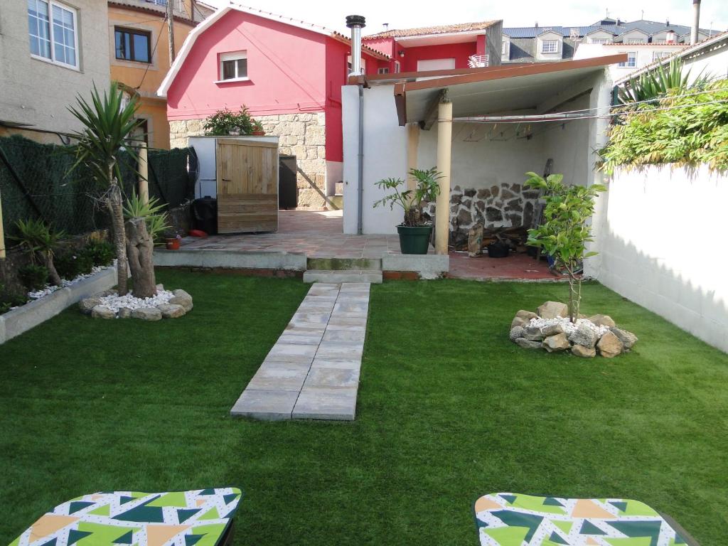 格罗韦Casa de Joaquina的一个带绿草庭院的小后院