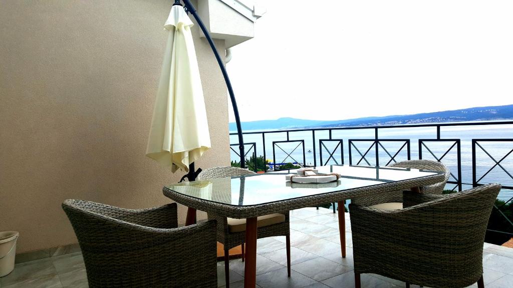 茨里克韦尼察Apartments Villa Harmonie - Adults Only +14的阳台上配有桌椅和遮阳伞