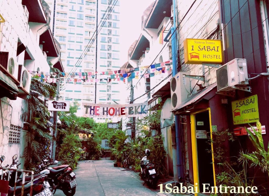 曼谷伊莎白旅舍的一条城市街道,有建筑和希望酒吧的标志