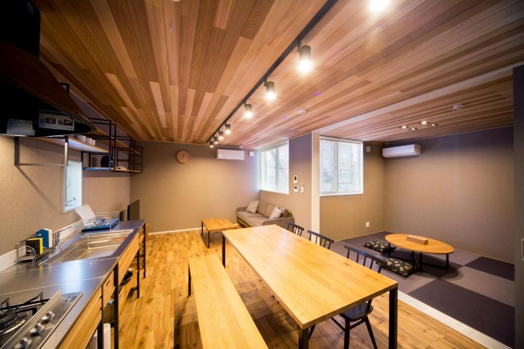 松江市Rakuten STAY HOUSE x WILL STYLE Matsue 101的厨房和带木制天花板的客厅