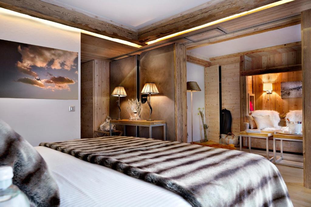 拉克吕萨爱心村社酒店的一间卧室配有一张带木墙的大床