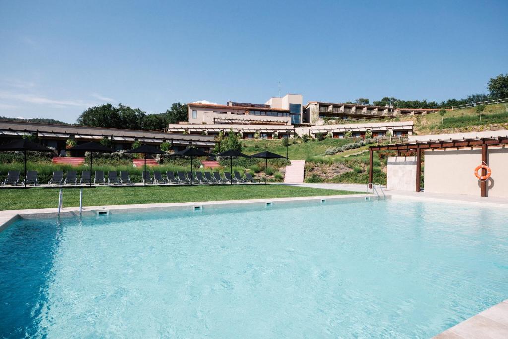 巴尔罗马内斯玛斯萨洛瑞斯SPA酒店的一座蓝色的大型游泳池,其建筑背景为: