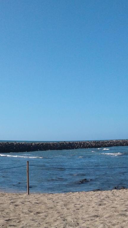 布兹尼盖Bahia Golf Beach的沙滩上,沙滩上,水里有一根杆